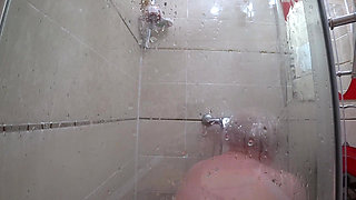 The camera is watching a mature chubby milf in the shower. Gorgeous fat ass, big natural boobs, hairy pussy. PAWG.