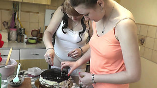 Women Day. Mature MILF and real virgin in short top T shirt without panties making cake kitchen for holiday. Girl on girl Kiss