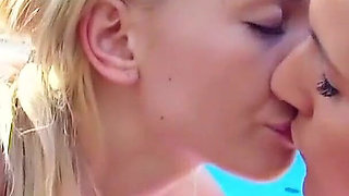 Two lesbian teens pamper each other on vacation at the pool