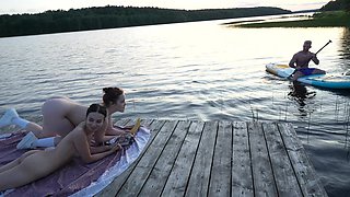 Slim teens were laying naked by the lake and lucky guy ended up in threesome